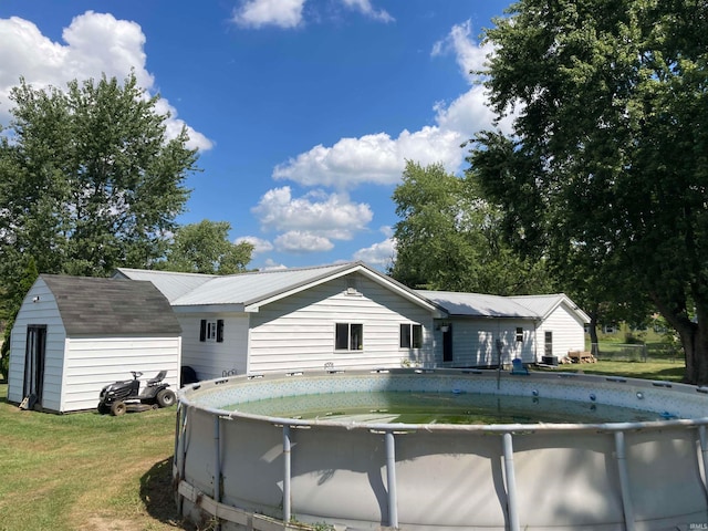 rear view of property featuring a storage unit and a yard