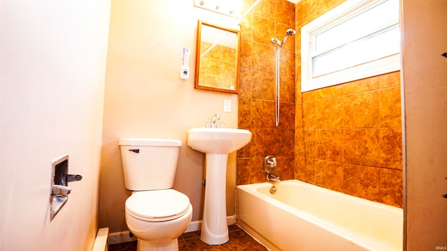 bathroom featuring tile patterned flooring, toilet, and tiled shower / bath combo