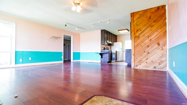 unfurnished living room with track lighting, ceiling fan, hardwood / wood-style flooring, and a textured ceiling