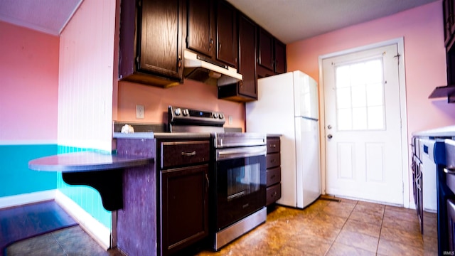 kitchen with light tile patterned floors, white fridge, electric range, and dark brown cabinets