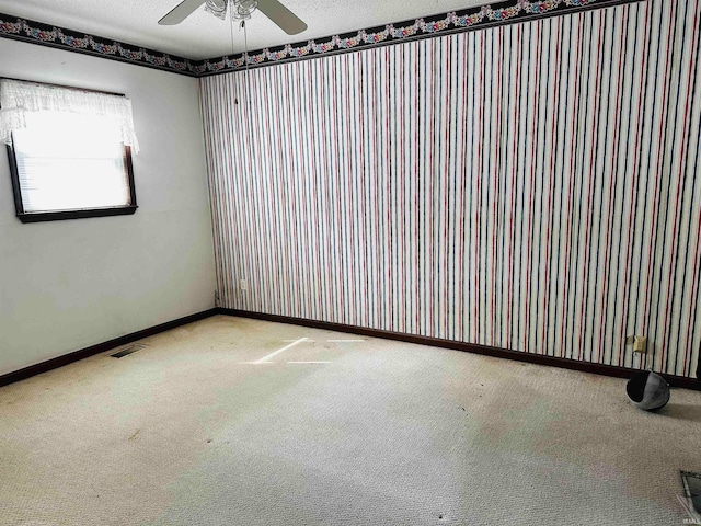 unfurnished room featuring ceiling fan, a textured ceiling, and carpet floors