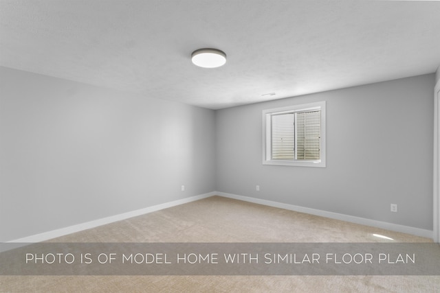 unfurnished room featuring carpet flooring and baseboards