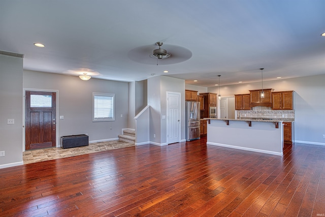 unfurnished living room featuring ceiling fan and dark hardwood / wood-style floors