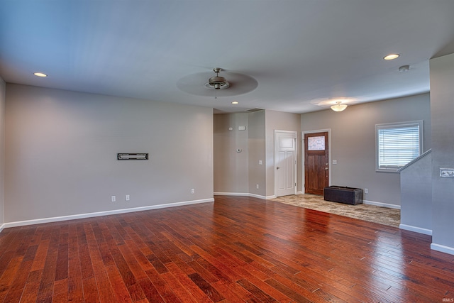 unfurnished living room featuring dark hardwood / wood-style flooring and ceiling fan