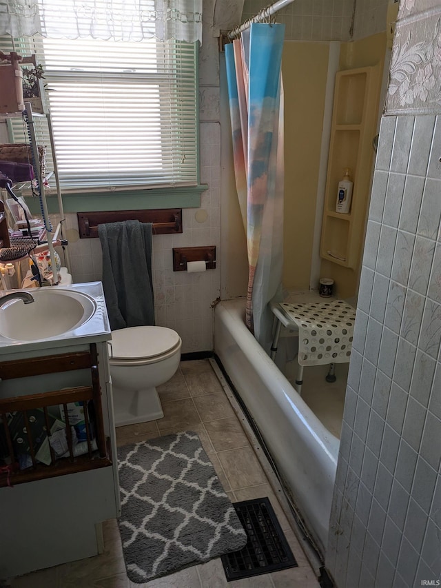 full bathroom featuring tile patterned flooring, toilet, vanity, visible vents, and tile walls