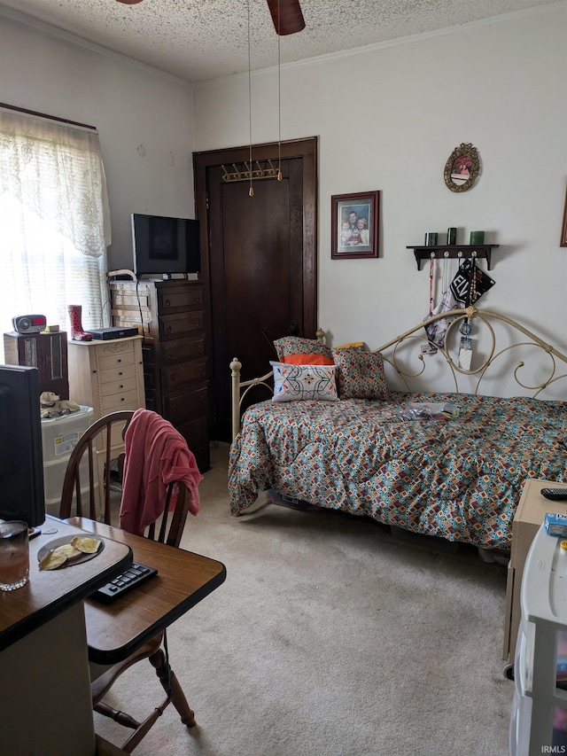 bedroom with a textured ceiling, ceiling fan, carpet, and crown molding