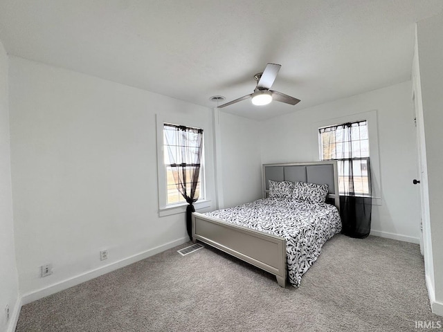 carpeted bedroom featuring multiple windows, visible vents, and baseboards