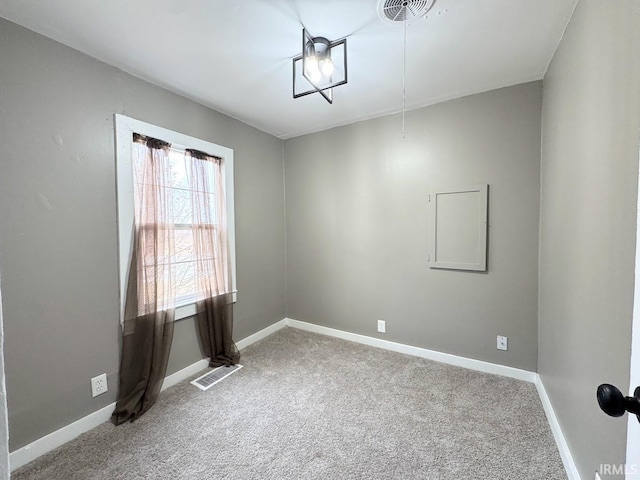 carpeted empty room featuring visible vents and baseboards