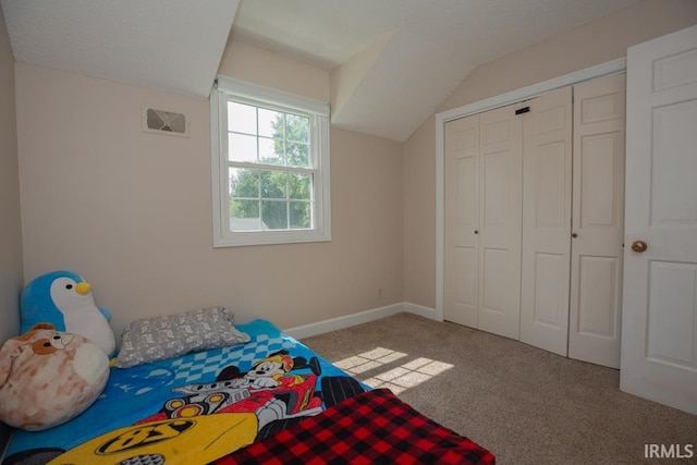 unfurnished bedroom with lofted ceiling, a closet, and light carpet