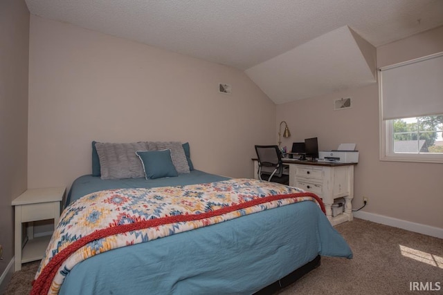 carpeted bedroom with a textured ceiling and vaulted ceiling