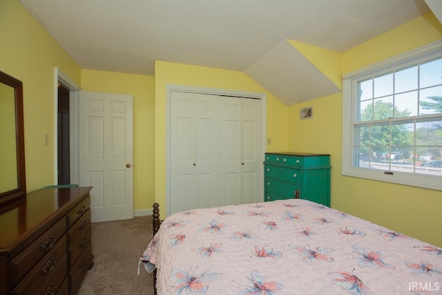 bedroom with a textured ceiling, carpet floors, and a closet