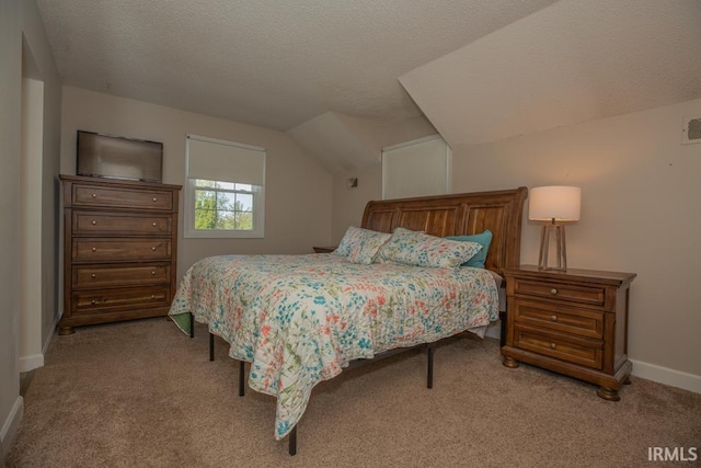 carpeted bedroom featuring a textured ceiling and vaulted ceiling