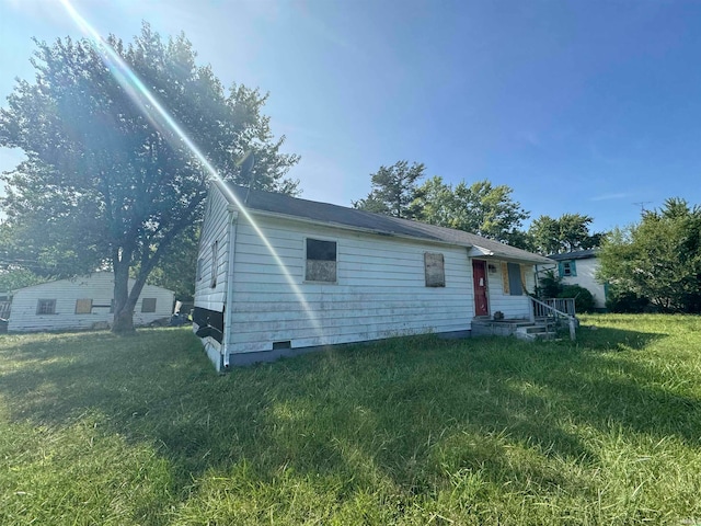 rear view of property featuring a yard