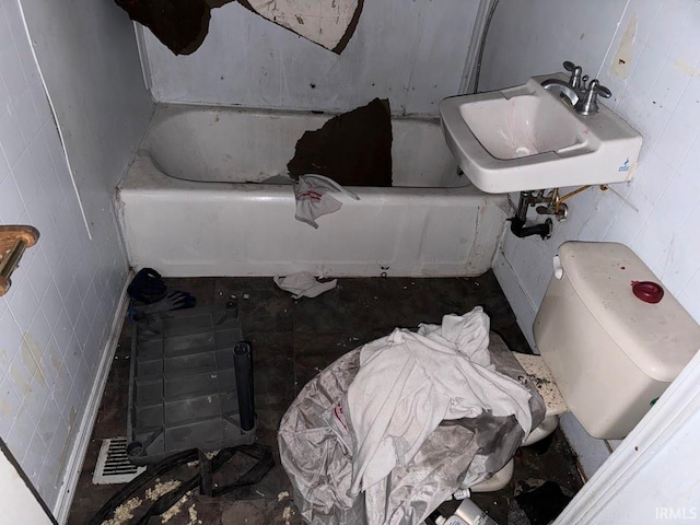 bathroom with toilet, sink, and a washtub