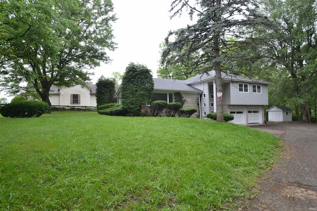 view of front of house with an outbuilding, a garage, and a front yard