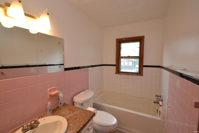 bathroom featuring toilet, tile walls, a bathtub, tasteful backsplash, and vanity