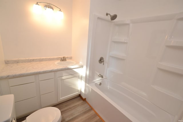 full bathroom featuring vanity, toilet, wood-type flooring, and shower / washtub combination