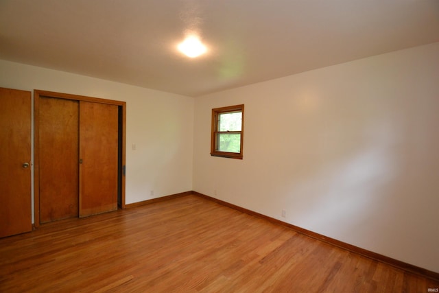 unfurnished bedroom featuring light hardwood / wood-style flooring and a closet