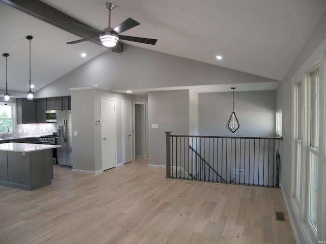 kitchen featuring pendant lighting, light countertops, visible vents, light wood-style flooring, and stainless steel fridge