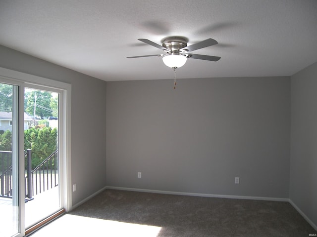 carpeted spare room featuring a textured ceiling, a ceiling fan, and baseboards