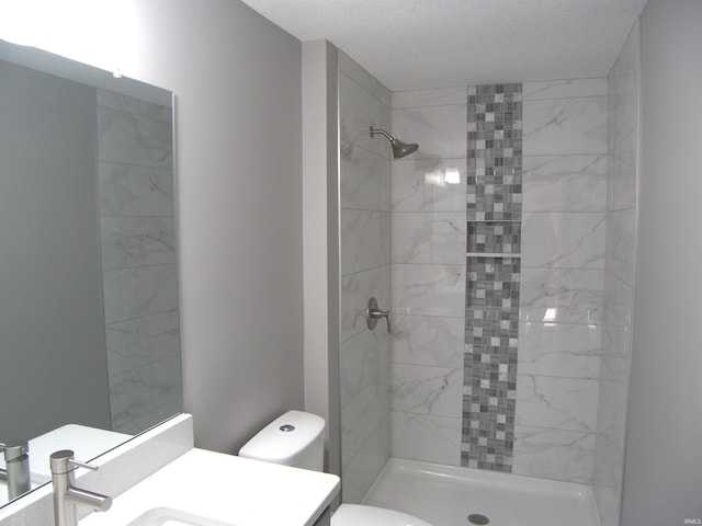 full bath featuring a textured ceiling, a shower stall, toilet, and vanity