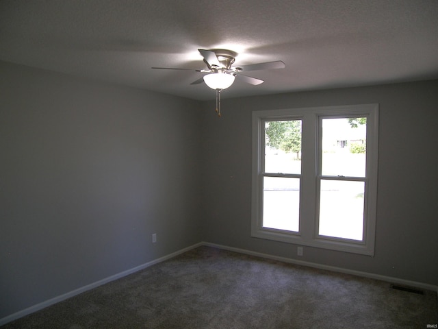 empty room with carpet, visible vents, ceiling fan, and baseboards