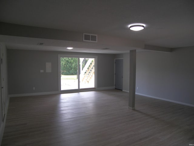 spare room featuring visible vents, baseboards, and wood finished floors