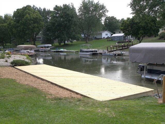 dock area with a water view and a lawn