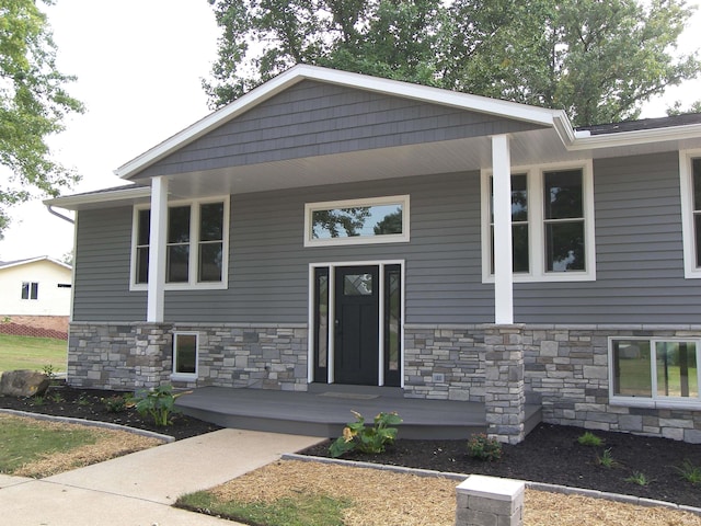 view of front of house with stone siding and a porch