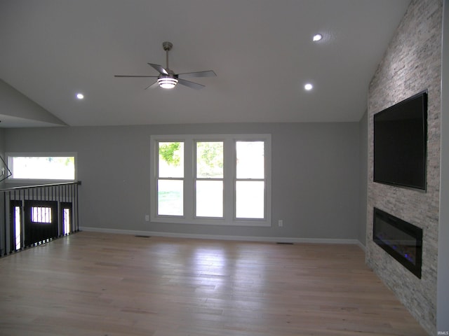 unfurnished living room featuring ceiling fan, a stone fireplace, recessed lighting, baseboards, and light wood-style floors