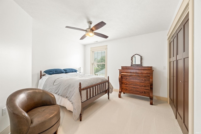 carpeted bedroom featuring ceiling fan and a closet