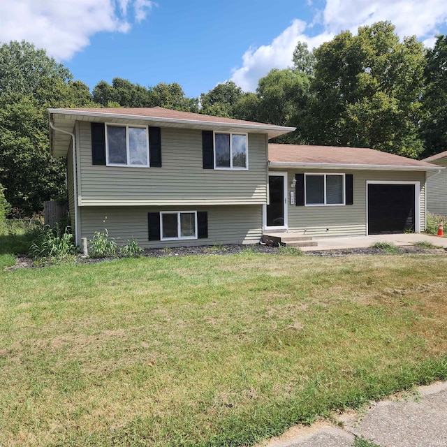 tri-level home featuring a garage and a front lawn