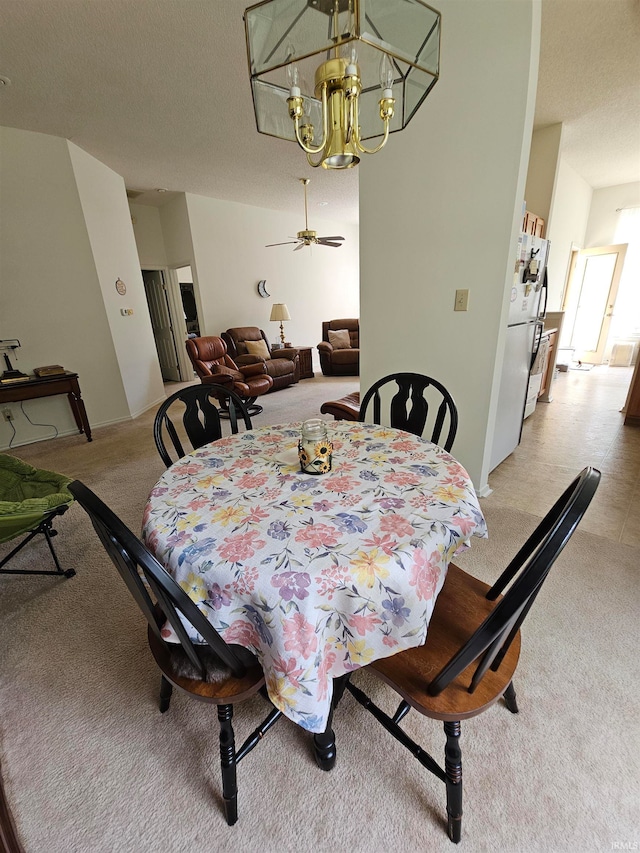 carpeted dining space with ceiling fan with notable chandelier and a textured ceiling