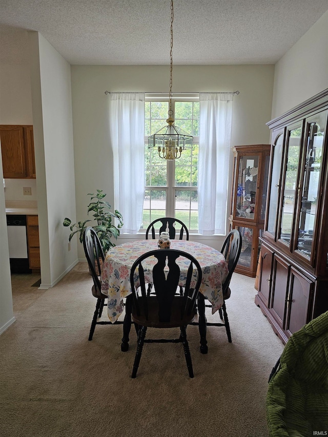 dining space with a chandelier, light carpet, and a textured ceiling