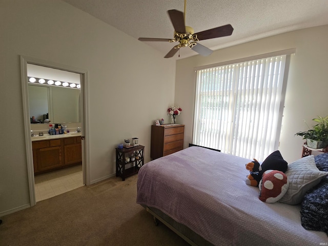 carpeted bedroom featuring a textured ceiling, sink, ensuite bathroom, and ceiling fan