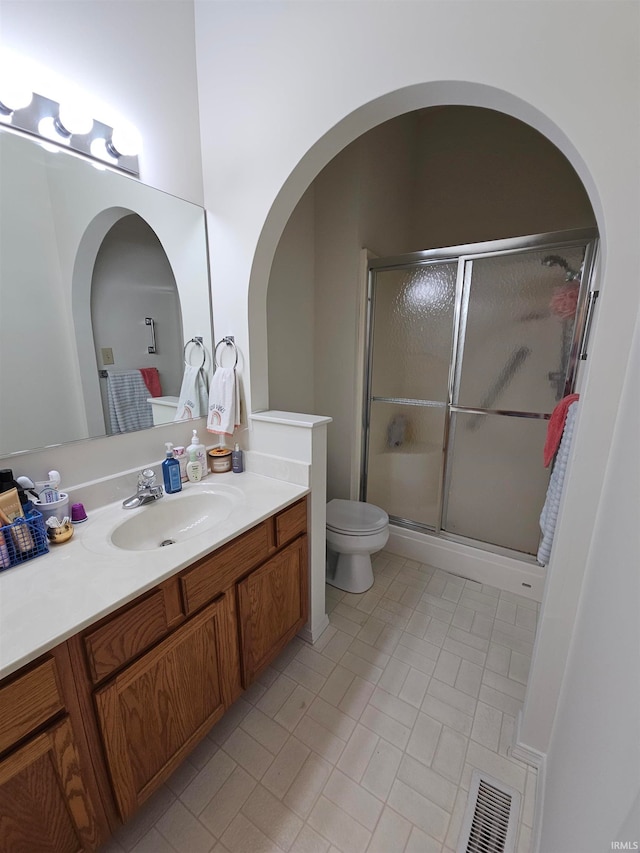 bathroom with vanity, toilet, and walk in shower