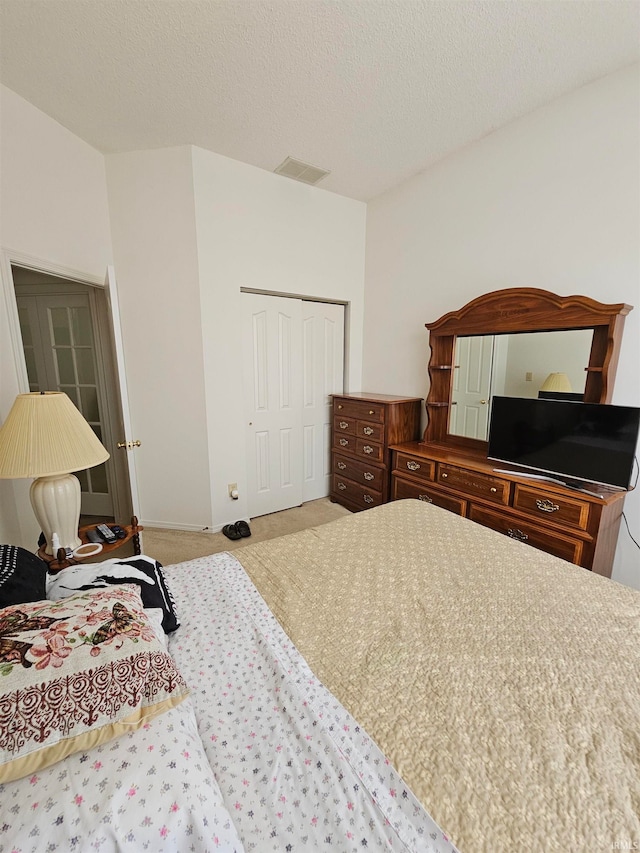 carpeted bedroom featuring a closet and a textured ceiling