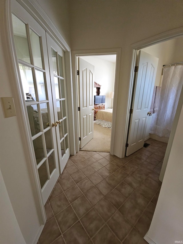 corridor featuring tile patterned flooring and french doors