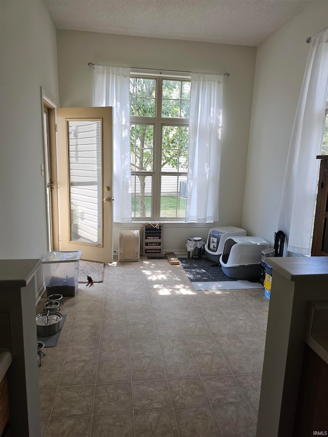 sitting room featuring a textured ceiling, a healthy amount of sunlight, and tile patterned flooring