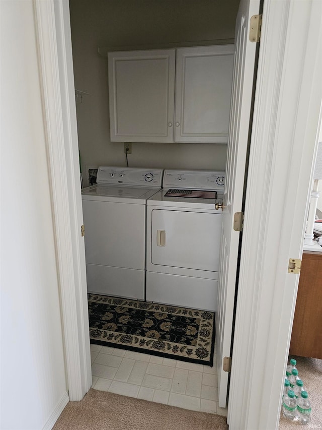 laundry room with cabinets, washing machine and clothes dryer, and tile patterned flooring