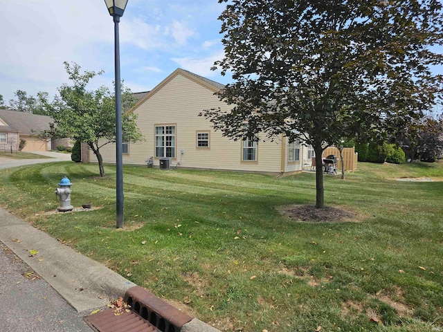 view of side of property with a yard and cooling unit