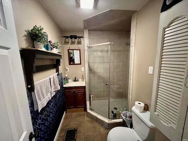 bathroom featuring vanity, toilet, tile patterned flooring, and a shower with door