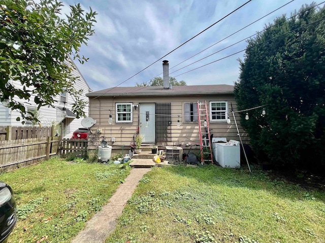 rear view of property featuring a lawn