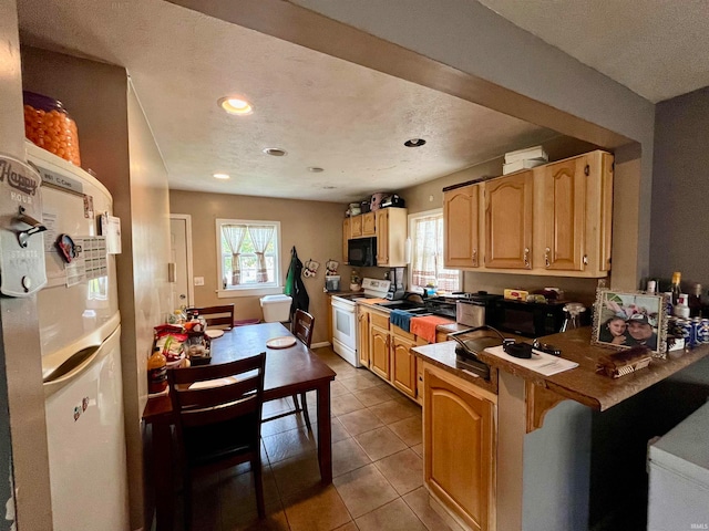 kitchen with a kitchen breakfast bar, white appliances, light brown cabinetry, light tile patterned floors, and kitchen peninsula