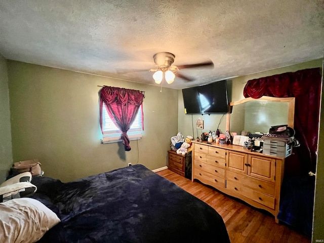 bedroom featuring a textured ceiling, ceiling fan, and hardwood / wood-style flooring