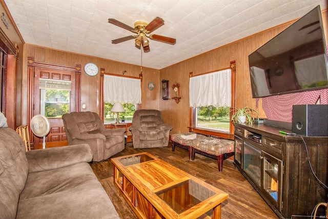 living room with wood walls, ceiling fan, and wood-type flooring