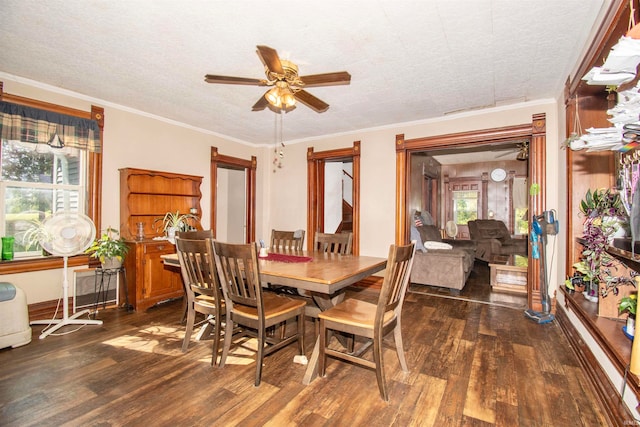 dining room with a wealth of natural light, dark wood-type flooring, ceiling fan, and ornamental molding