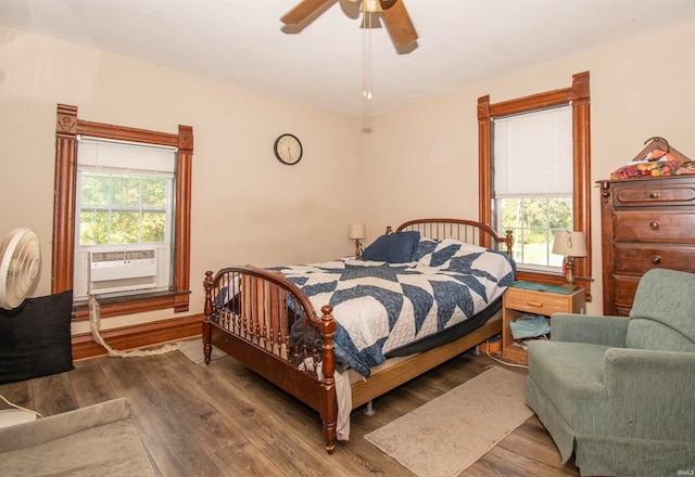 bedroom with cooling unit, ceiling fan, and dark hardwood / wood-style floors