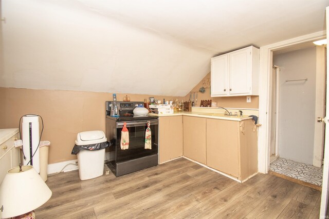 kitchen with electric range, light hardwood / wood-style floors, sink, lofted ceiling, and kitchen peninsula