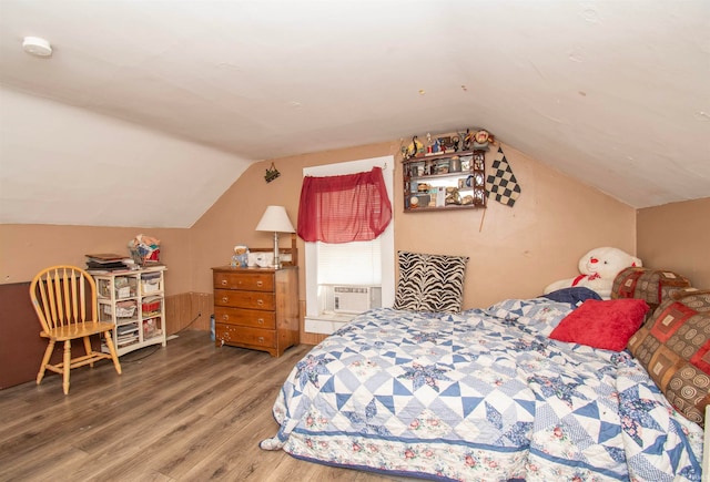 bedroom with lofted ceiling, cooling unit, and hardwood / wood-style flooring